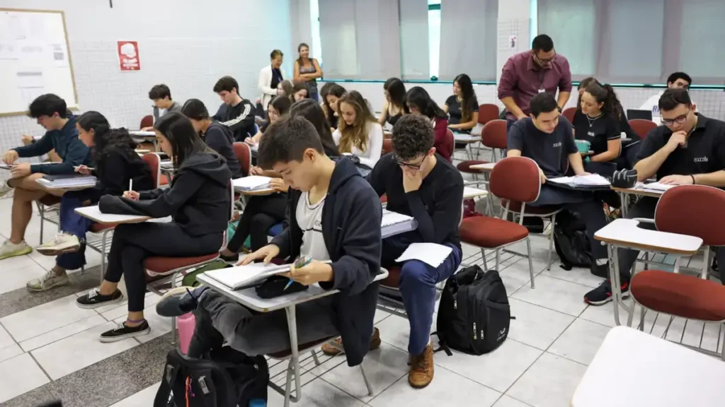 Imagem atual: Estudantes concentrados durante prova em sala de aula de cursinho pré-vestibular.