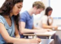 Estudantes fazendo prova em sala de aula.