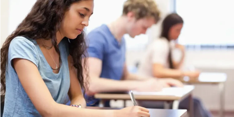 Estudantes fazendo prova em sala de aula.