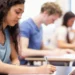 Estudantes fazendo prova em sala de aula.