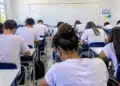 Alunos fazendo prova em sala de aula.