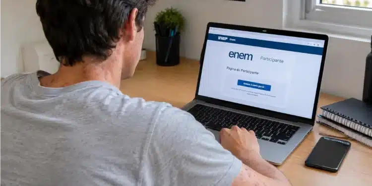 Jovem com manchas vermelhas no corpo, olhando para página do Enem no notebook.