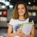 Estudante universitária sorrindo em biblioteca moderna.