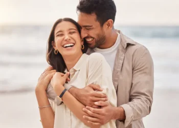 Casal sorrindo na praia.
