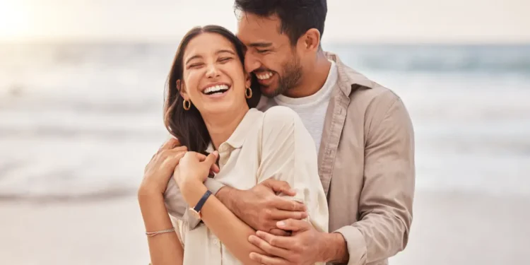 Casal sorrindo na praia.