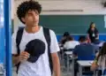 Estudante segura um boné nas mãos antes de entrar na sala de prova, representando as regras para o uso de chapéus e bonés durante o Enem.