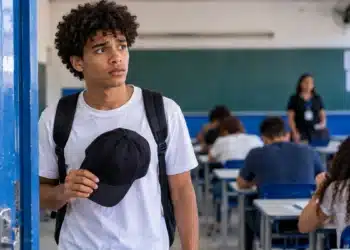 Estudante segura um boné nas mãos antes de entrar na sala de prova, representando as regras para o uso de chapéus e bonés durante o Enem.