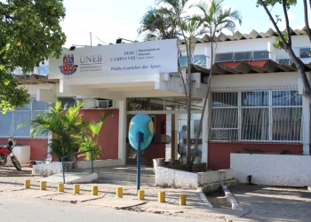 Imagem ilustrativa da fachada do Campus VIII da UNEB, em Paulo Afonso, com letreiro da universidade e palmeiras na entrada, representando os campi do vestibular UNEB 2027