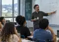 Professor apresenta conteúdo no quadro aos alunos em sala de aula.