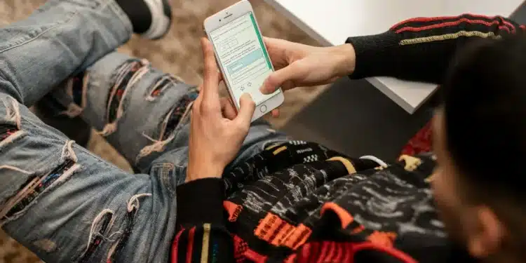 Jovem com mochila consulta o celular, como quem confere o cartão de confirmação do Enem 2026