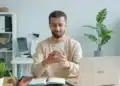 Homem sorri ao conferir a carteira de trabalho digital no celular depois de ser contratado