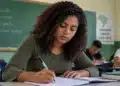 Estudante escreve em caderno durante atividade escolar, representando a preparação para uma redação sobre a importância do voto e da cidadania.