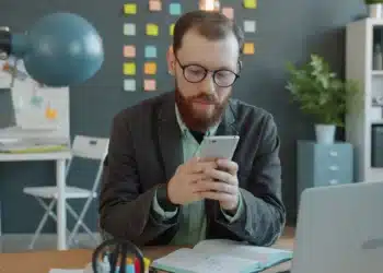 Servidor de óculos usa o celular na mesa do escritório para indicar órgão no SouGov, etapa do CNU 2 para ATDS e ATJD