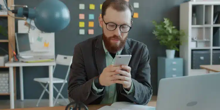 Servidor de óculos usa o celular na mesa do escritório para indicar órgão no SouGov, etapa do CNU 2 para ATDS e ATJD