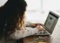 Mulher usando notebook para fazer a inscrição no concurso CGU para auditor federal