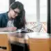 Candidata do concurso TRT-4 estudando com livro e caneta em uma mesa