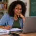 Professora mexendo no notebook, com livro de neuroeducação sobre a mesa, representando o curso online de Formação de Professores em Neuroeducação oferecido pelo MEC.