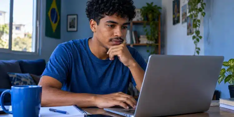 Jovem acessa notebook, representando a consulta de vagas e a inscrição em cursos gratuitos de idiomas do Mover.