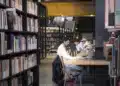 Estudantes leem e estudam em mesas de uma biblioteca moderna, cena ligada ao Dia Nacional do Livro