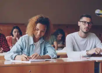 Estudantes concentrados escrevendo em sala, imagem sobre como dividir o tempo no Enem 2026