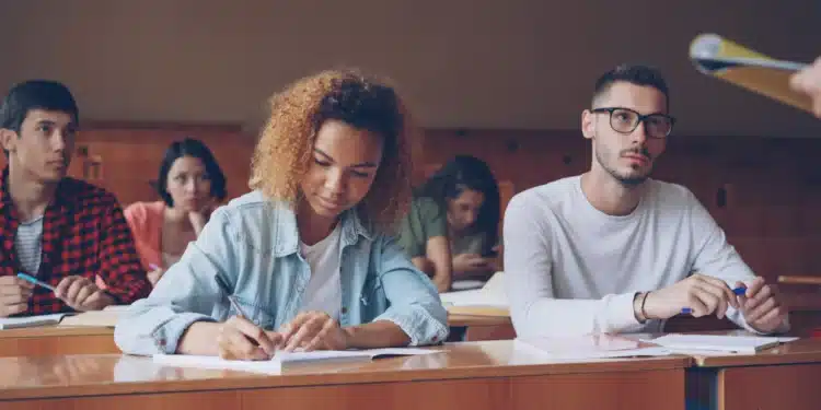 Estudantes concentrados escrevendo em sala, imagem sobre como dividir o tempo no Enem 2026