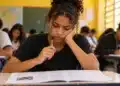 Estudante analisa questões de uma prova com expressão de dúvida, representando a decisão entre chutar ou deixar respostas em branco no Enem 2026.