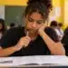Estudante analisa questões de uma prova com expressão de dúvida, representando a decisão entre chutar ou deixar respostas em branco no Enem 2026.