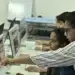 Professor orienta alunos no computador em sala de aula, exemplo de educação digital prevista na LDB