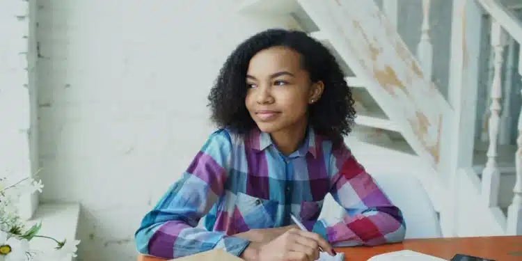 Jovem candidata do Enem 2026 estudando em uma mesa com cadernos e livros
