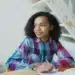 Jovem candidata do Enem 2026 estudando em uma mesa com cadernos e livros