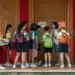 Estudantes com mochilas reunidos na entrada de uma escola, cena que lembra a chegada ao Enem 2026