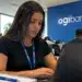 Jovem profissional utilizando notebook em escritório com identidade visual do Agibank, representando as oportunidades de estágio com bolsa-auxílio de R$ 2.400.