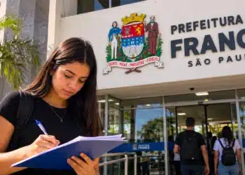 Jovem escreve em frente à Prefeitura de Franca, representando o estágio com inscrições abertas até 29 de outubro.