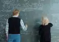 Dois estudantes resolvem exercícios de matemática no quadro, exemplo de estudo intercalado com tipos de problema misturados