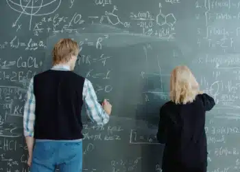 Dois estudantes resolvem exercícios de matemática no quadro, exemplo de estudo intercalado com tipos de problema misturados