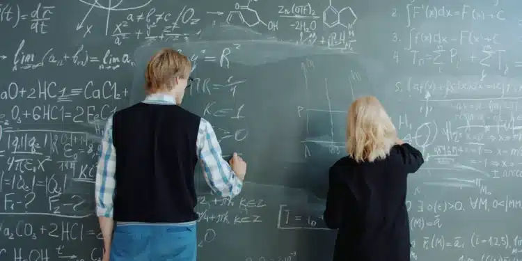Dois estudantes resolvem exercícios de matemática no quadro, exemplo de estudo intercalado com tipos de problema misturados
