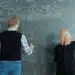 Dois estudantes resolvem exercícios de matemática no quadro, exemplo de estudo intercalado com tipos de problema misturados