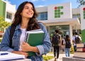 Imagem ilustrativa de estudante sorridente com cadernos em frente a um campus com a marca dos institutos federais, em referência à seleção para pós-graduação