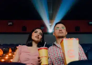 Duas jovens em poltronas de cinema, cena ligada à meia-entrada para estudante em eventos culturais