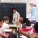 Professora diante da turma em sala de aula, cena ligada à educação inclusiva e ao apoio escolar