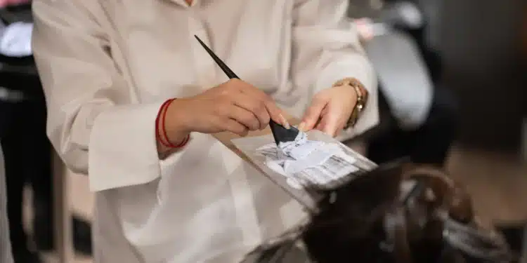 Cabeleireira corta o cabelo de uma cliente em salão de beleza, cena ligada ao contrato de salão-parceiro