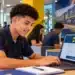 Jovem utilizando notebook com o logotipo da MRS Logística, representando a inscrição no Programa Aprendiz da empresa.