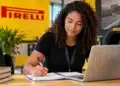 Jovem estudante participa de atividade em ambiente da Pirelli com notebook e caderno