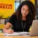 Jovem estudante participa de atividade em ambiente da Pirelli com notebook e caderno