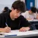 Estudante concentrado respondendo questões em sala de aula durante prova, ilustrando a participação de treineiros na primeira fase da Unicamp 2027.