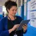 Gestora escolar consultando dados educacionais em tablet, representando a consulta aos relatórios do Ideb 2025 por município.