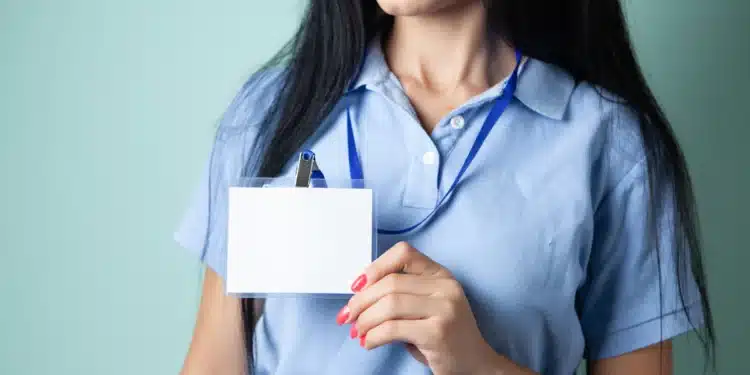 Mulher segura um cartão em branco, como um documento de identidade, ilustrando a validade do RG modelo antigo