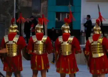 Recriadores vestidos de soldados romanos marchando em formação, tema da origem da palavra salário