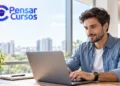 Homem utiliza um notebook em escritório moderno, com o logotipo do Pensar Cursos no canto superior esquerdo.