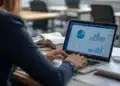 Mulher analisa gráficos e planilhas no notebook, tarefa ensinada na Trilha Analista Financeiro com Power BI